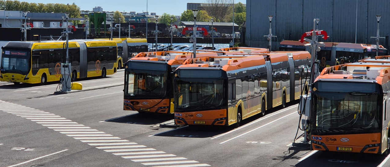 4 electric buses charging in a depot