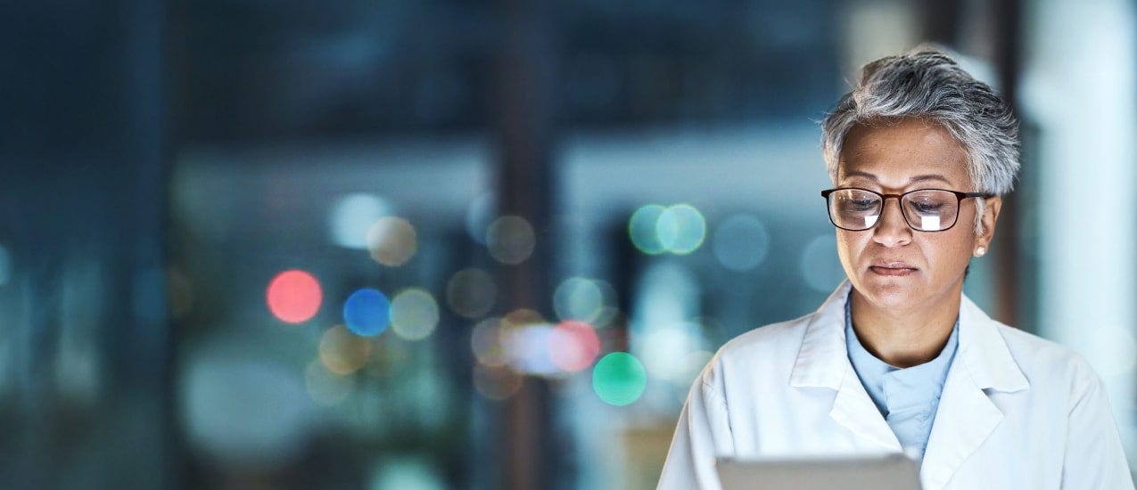 A person wearing glasses and a white lab coat