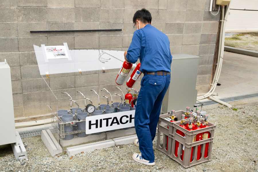 A delivery driver connecting the small cylinders to a fuel cell