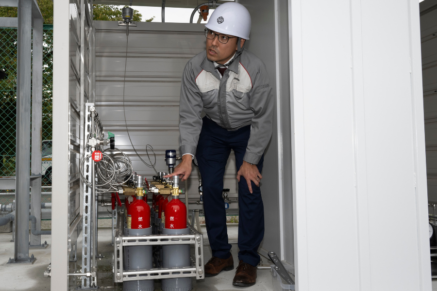 Watanabe of Hitachi explaining the process to fill small cylinders with hydrogen
