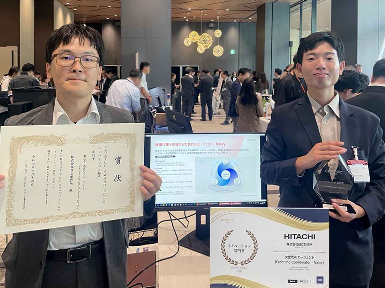 CEATEC AWARD 2025発表 併設展示会場での様子 日立製作所 研究開発グループ 先端AIイノベーションセンタ 秋山 リーダー主任研究員、平川 研究員