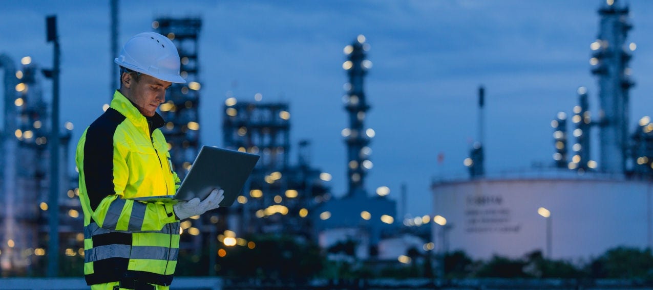 Industrial worker using a tablet to monitor operations at a power grid