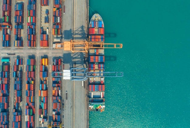 Aerial view of a shipping container terminal, highlighting the importance of connected data and operational intelligence in industrial logistics.