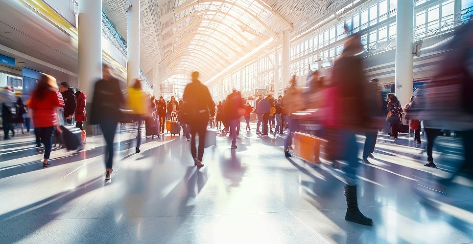 A busy indoor place, numerous people walking in various directions