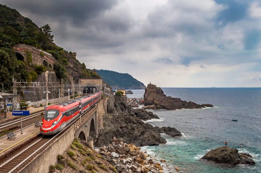 Hitachi Train passing through Framura station on a coastal railway
