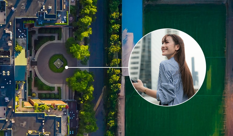 Aerial view of a landscaped area. A circular inset zooms in on a person smiling