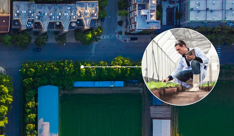 Aerial video of an urban area. Inset cirlce zooms in showing a person in a greenhouse inspecting plants