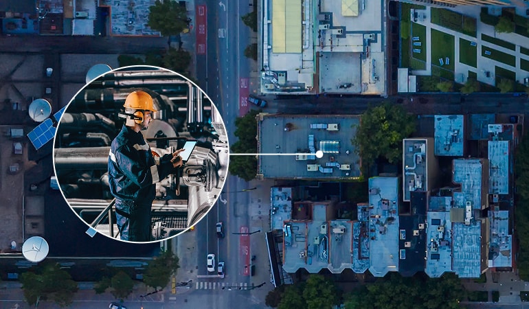 Aerial view of city building. A circular inset zooms in on a worker wearing a safety gear using a tablet