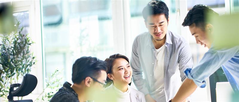 group of four happy young asian corporate executives working together meeting in office discussing business in office. group of four happy young asian corporate executives working together meeting in office discussing business in office.